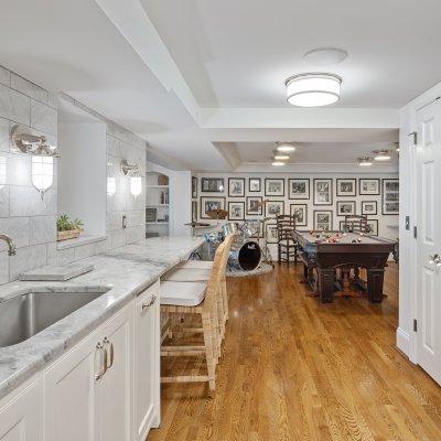 renovated basement kitchenette white cabinets pool table